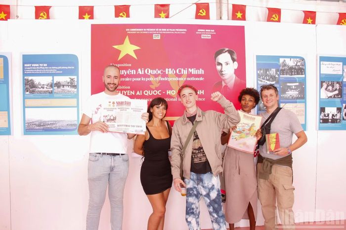 Nhóm các bạn trẻ người Pháp Hugo (giữa), Guillem (bìa trái) và Fatimah (thứ 2 từ phải sang) chụp ảnh lưu niệm tại gian trưng bày về Việt Nam do Báo Nhân Dân tổ chức tại Hội báo Nhân đạo 2026. (Ảnh: TRUNG HƯNG)