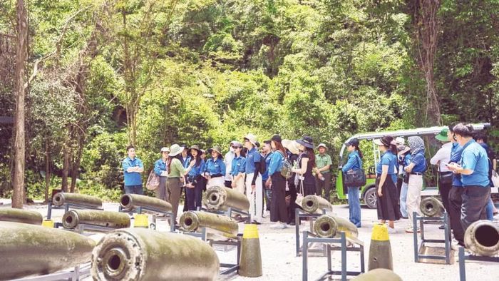 Du khách tham quan khu trưng bày chứng tích bom mìn ngoài trời tại Hang Chỉ Huy.