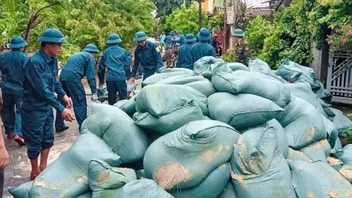 Lực lượng chức năng làm việc xuyên trưa để nhanh chóng gia cố đoạn đường sụt lún để bảo đảm an toàn trong mùa mưa lũ. (Ảnh: LT)