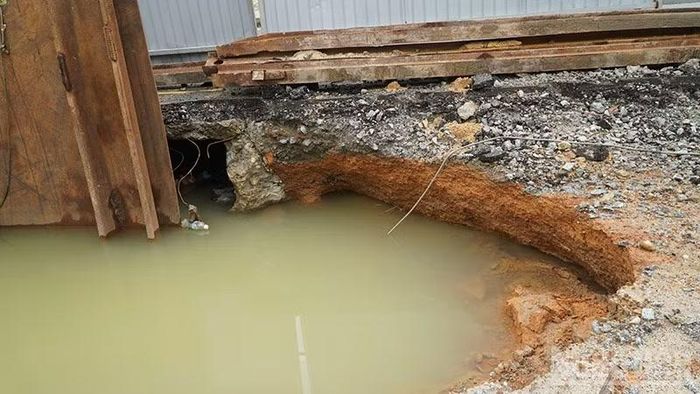 Do công trình thi công dở dang mà vỉa hè trước nhà dân đã sụt lún và tạo thành hố sâu rất nguy hiểm. (Ảnh: QV)