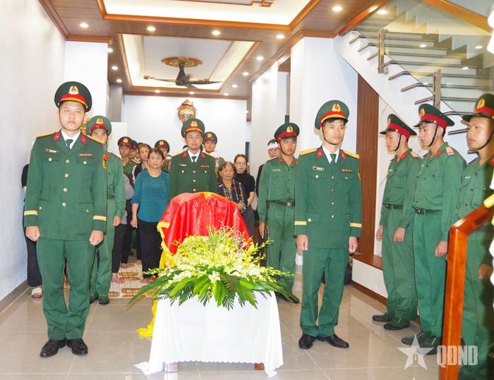 Đồng đội và người thân bên di cốt của Trung tá Trần Văn Tùng.