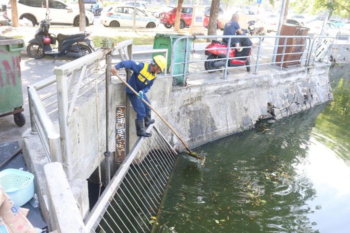 Công nhân Cty Thoát nước và xử lý nước thải Đà Nẵng khơi thông cửa van của hồ điều tiết Thạc Gián.