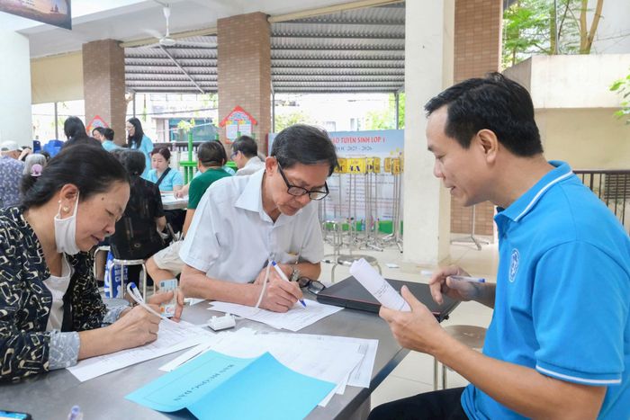  Hướng dẫn người dân làm thủ tục tham gia BHXH. Ảnh: VŨ QUÂN 
