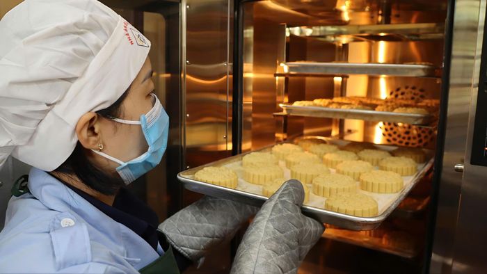 Đưa bánh vào lò nướng. Ảnh: HỮU PHÚC