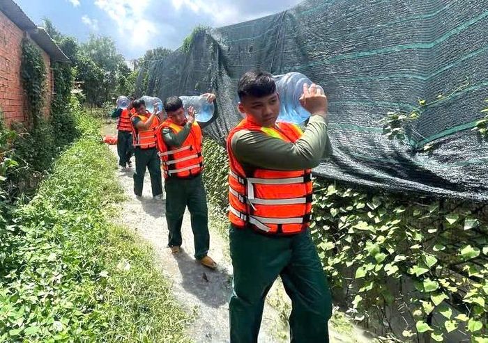  Lực lượng dân quân được huy động hỗ trợ người dân những ngày bị ngập úng. Ảnh: LÊ XUÂN 