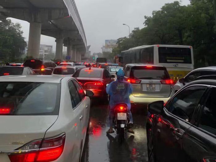 Dưới cơn mưa, dòng xe nhích từng chút.