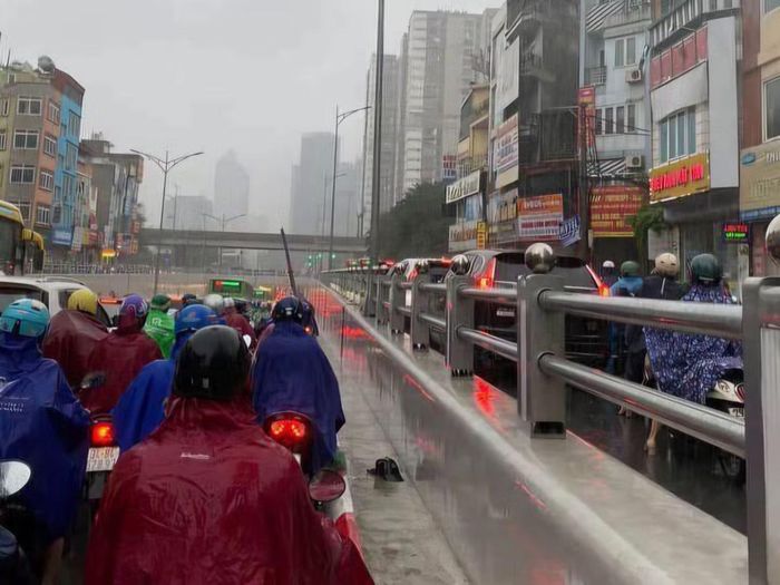 Nút giao Tố Hữu - Lê Văn Lương dòng người dịch chuyển khó khăn trong cơn mưa.