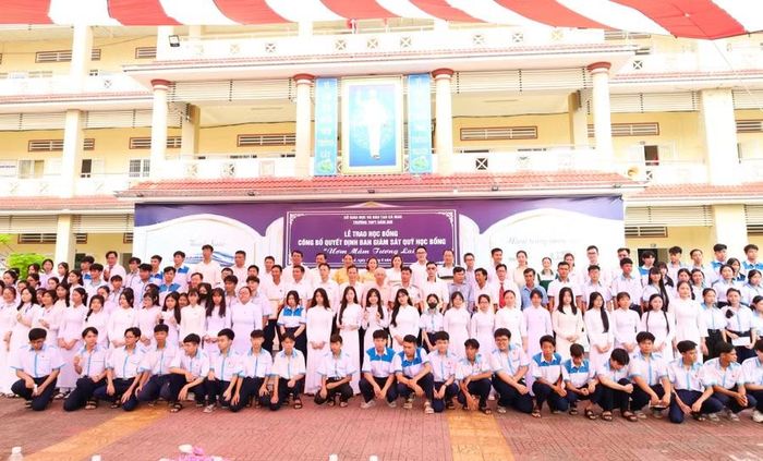 Nhà hảo tâm chụp ảnh lưu niệm cùng học sinh nhận học bổng.