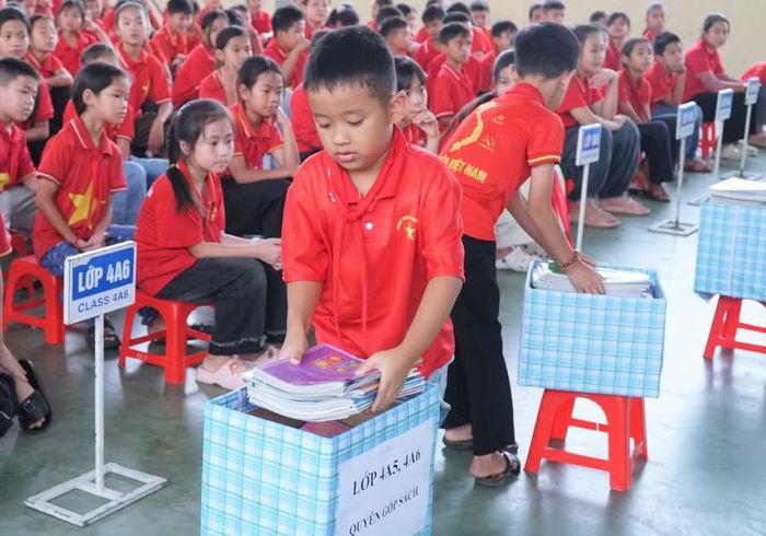 Học sinh Trường Tiểu học Nghi Văn (xã Nghi Văn, Nghệ An) quyên góp sách tặng cho bạn học khó khăn và tủ sách dùng chung. Ảnh: Hồ Lài