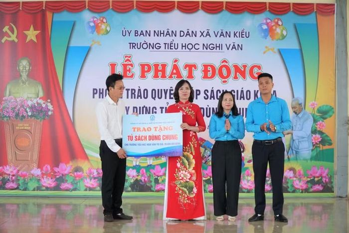 Công ty Sách và thiết bị trường học tỉnh Nghệ An trao tặng tủ sách dùng chung cho Trường Tiểu học Nghi Văn, Nghệ An. Ảnh: Hồ Lài