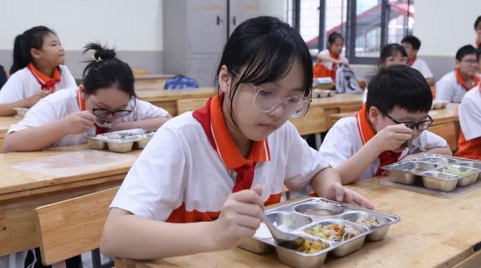 Các suất ăn của học sinh THCS chia sẵn ở khay sau đó được vận chuyển lên lớp. Ảnh NC.