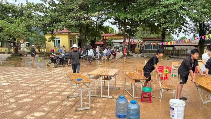 Nước dâng khiến lượng bùn lớn tràn vào sân trường.
