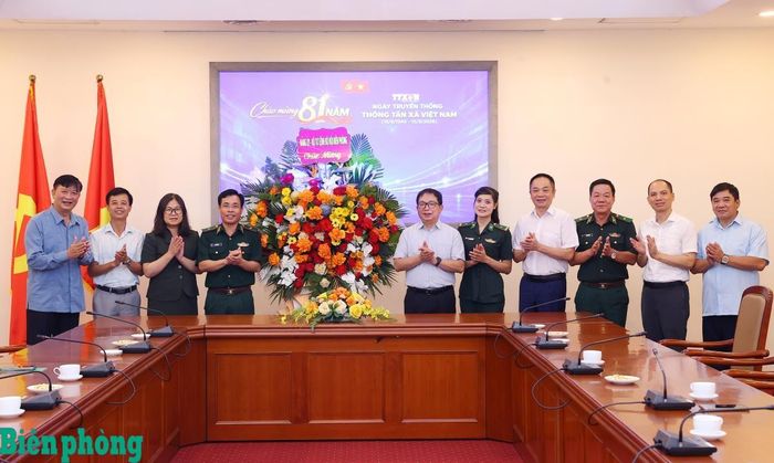 Thiếu tướng Vũ Quốc Ân (thứ 4, từ trái sang) và Thiếu tướng Văn Ngọc Quế (thứ 3, từ phải sang) tặng hoa chúc mừng Thông tấn xã Việt Nam nhân Ngày truyền thống. Ảnh: TK