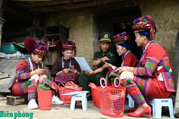 Cán bộ Đồn Biên phòng Sì Lờ Lầu, Bộ đội Biên phòng tỉnh Lai Châu hướng dẫn người dân Hà Nhì sử dụng điện thoại thông minh để tiếp cận các nền tảng số ở bản Tỷ Phùng, xã Sì Lở Lầu, tỉnh Lai Châu. Ảnh: Đức Duẩn