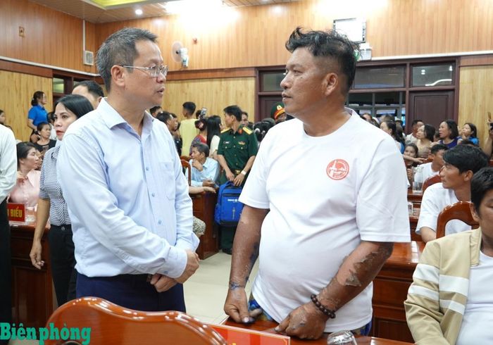 Đồng chí Nguyễn Mạnh Hùng (bên trái) thăm hỏi thuyền trưởng Huỳnh Văn Trí. Ảnh: Trúc Hà