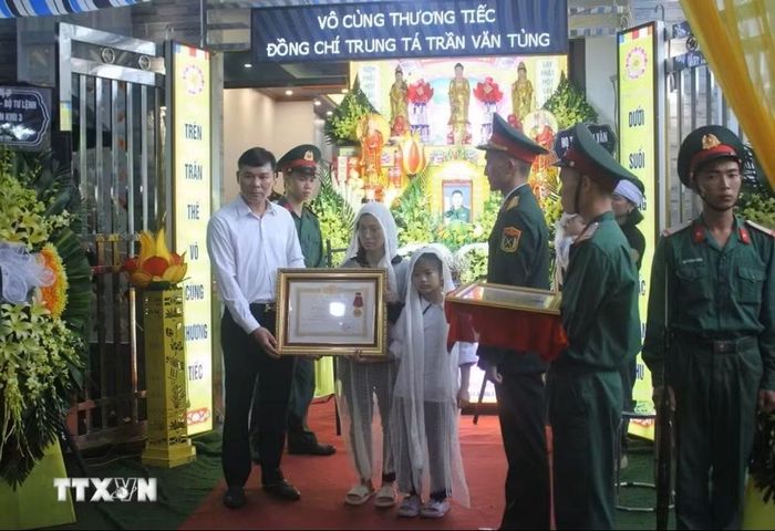 Thừa ủy quyền của Chủ tịch nước, Phó Chủ tịch Thường trực UBND tỉnh Hưng Yên Nguyễn Lê Huy đã trao Huân chương Dũng cảm truy tặng Trung tá Trần Văn Tùng cho thân nhân Trung tá Tùng. Ảnh: TTXVN