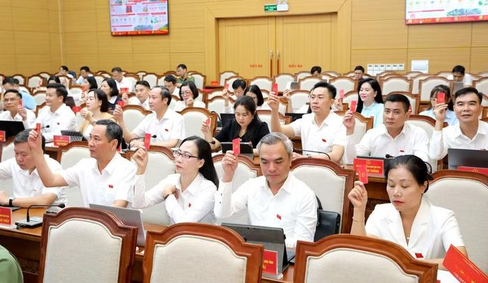 Các đại biểu biểu quyết thông qua các nghị quyết của Kỳ họp. Ảnh: laocai.gov.vn