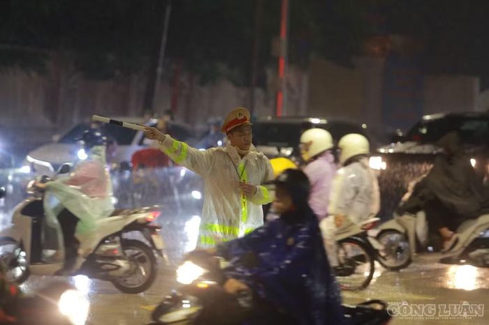 Lực lượng chức năng căng mình phân luồng giao thông dưới cơn mưa lớn.