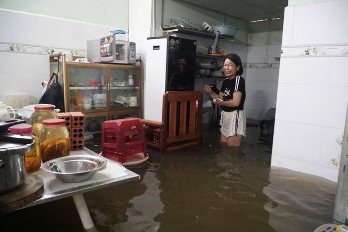 Sau cơn mưa lớn vào đêm 10/9, đến sáng 11/9, chị Đỗ Thị Thanh Tâm vẫn phải sống chung với ngập. Ảnh: Nguyễn Tiến