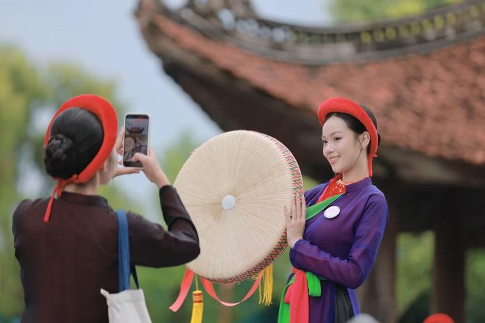Thí sinh giúp nhau ghi lại bức ảnh kỷ niệm với trang phục quan họ.