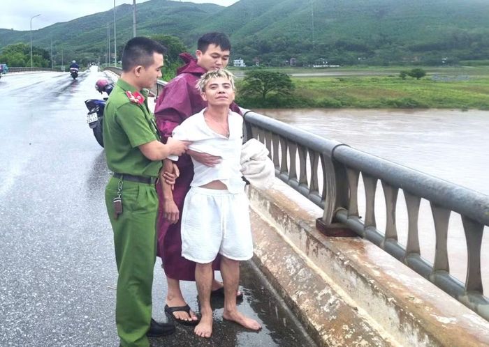 Bằng các biện pháp phù hợp, cán bộ công an áp sát, khống chế và đưa nam thanh niên rời khỏi lan can cầu.