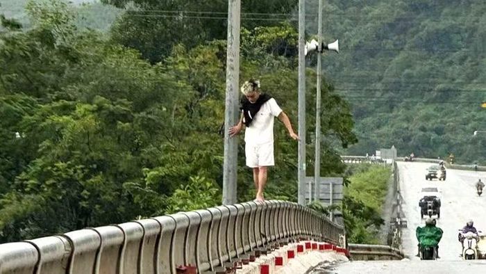 Nam thanh niên có hành động nguy hiểm trên lan can cầu.