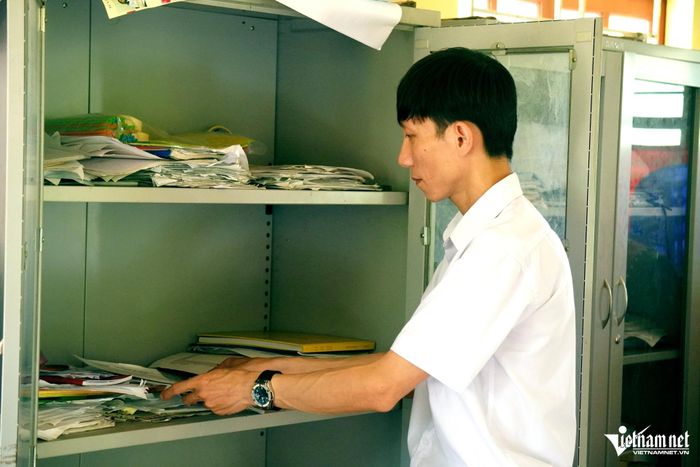 Trưởng bản Hà Văn Đốc sắp xếp tài liệu của thôn. Ảnh: Lê Dương