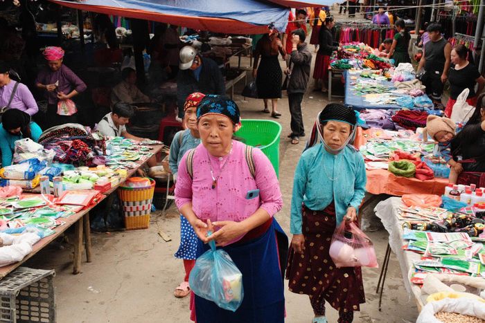 Từ sáng sớm, người dân ở các bản quanh vùng mặc trang phục truyền thống, đi bộ hoặc xe máy xuống chợ. Người mang rau củ, ngô, mật ong, nông sản; người bán gia súc, gia cầm, nông cụ và những vật dụng thiết yếu