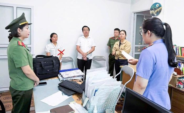 Kiểm sát viên kiểm sát việc thi hành Lệnh khám xét nơi làm việc của Nguyễn Thị Hương, kế toán Công ty cổ phần đầu tư xây dựng Duy Mạnh. Ảnh: CAPT