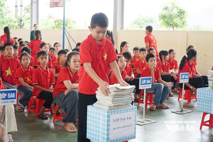 Các em học sinh Trường Tiểu học Nghi Văn đóng góp sách giáo khoa cho “Tủ sách dùng chung” của nhà trường. Ảnh: Thanh Hà