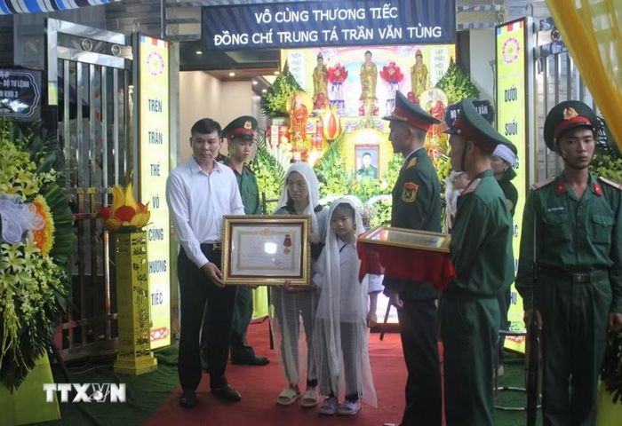 Thừa ủy quyền của Chủ tịch nước, Phó Chủ tịch Thường trực Ủy ban Nhân dân tỉnh Hưng Yên Nguyễn Lê Huy đã trao Huân chương Dũng cảm truy tặng Trung tá Trần Văn Tùng cho thân nhân Trung tá Tùng. (Ảnh: Nguyễn Công Hải/TTXVN)