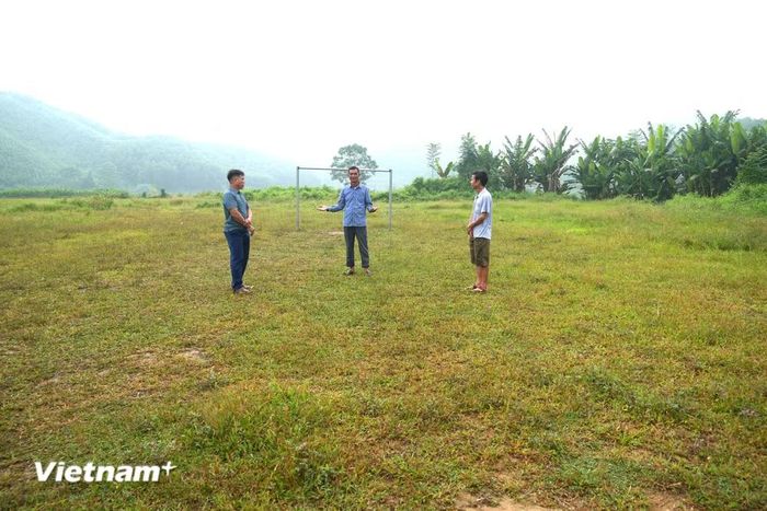 Ông Mã Phúc Hương cùng cán bộ thôn bên sân bóng của thôn Làng Hản. (Ảnh: Minh Tâm/Vietnam+)