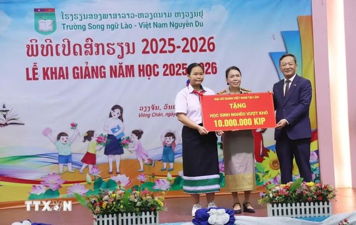 Đại sứ Việt Nam tại Lào Nguyễn Minh Tâm trao quà cho các học sinh có hoàn cảnh khó khăn, biết vươn lên trong học tập. (Ảnh: Xuân Tú/TTXVN)
