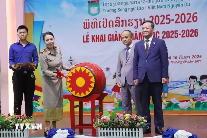 Hiệu trưởng Trường song ngữ Lào-Việt Nam Nguyễn Du Nguyễn Thị Thanh Hương đánh trống khai giảng năm học mới 2025-2026. (Ảnh: Xuân Tú/TTXVN)