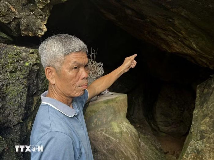 Ông Hà Văn Bức, bản Sại, xã Phú Lệ chỉ dẫn cửa hang Co Phương, nơi 11 liệt sỹ đã hy sinh năm 1953. (Ảnh: Hoa Mai/TTXVN)