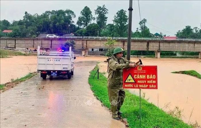 Lực lượng chức năng cắm biển báo ở cung đường ngập lụt. Ảnh: Công Tường/TTXVN