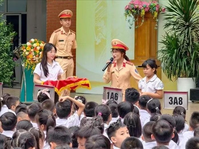 Trung tá Phan Thu Hiền, cán bộ Đội Cảnh sát giao thông đường bộ số 4 (Phòng Cảnh sát giao thông Hà Nội), hướng dẫn học sinh nhận biết và xử lý những tình huống thường gặp khi tham gia giao thông đường bộ. Ảnh: Trung Nguyên/TTXVN