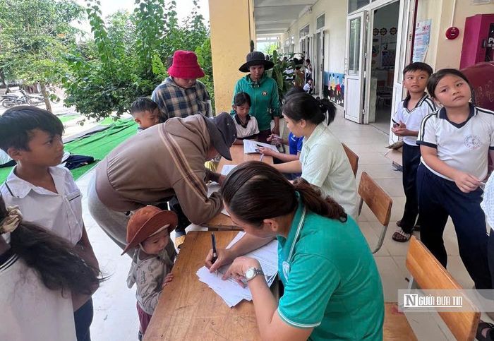Phụ huynh dẫn con đến trường khám sức khỏe.