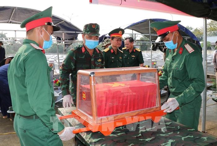 Lực lượng chức năng lấy mẫu hài cốt liệt sĩ chưa xác định được thông tin tại Nghĩa trang Liệt sĩ Cầu Ngang. Ảnh: Thanh Hòa - TTXVN