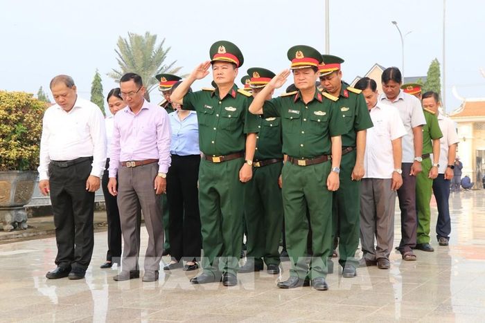 Các đại biểu dành phút mặc niệm tưởng nhớ các Anh hùng Liệt sĩ tại Nghĩa trang Liệt sĩ Cầu Ngang trước khi tiến hành lấy mẫu. Ảnh: Thanh Hòa - TTXVN