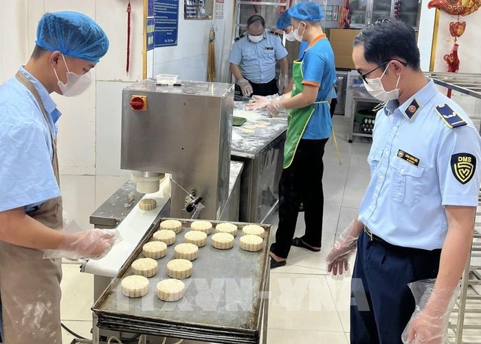 Đội Quản lý thị trường số 13, Chi cục Quản lý thị trường thành phố Hà Nội, rà soát, tuyên truyền vệ sinh an toàn thực phẩm cơ sở sản xuất, kinh doanh bánh Trung thu trên địa bàn phường Xuân Đỉnh (Hà Nội). Ảnh: Quốc Lũy - TTXVN