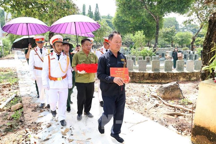 Ông Lê Văn Trung, em ruột liệt sĩ Lê Thái Cơ (dẫn đầu) cùng các đơn vị thực hiện nghi thức cất bốc hài cốt liệt sĩ Lê Thái Cơ tại Nghĩa trang liệt sĩ Đồi 82 Tân Biên Tây Ninh. Ảnh: Thanh Tân - TTXVN