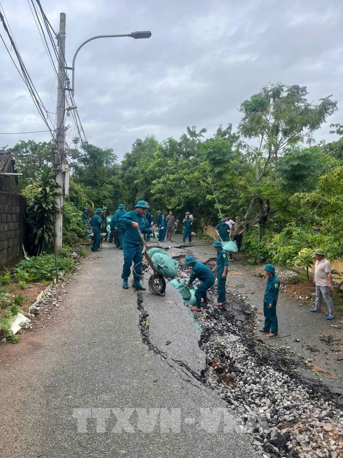 Chính quyền địa phương và các lực lượng chức năng tiến hành vận chuyển và xếp bao tải cát để hạn chế sạt lở tiếp tục lan rộng, ảnh hưởng đến công trình và an toàn của người dân tại khu vực xung yếu. Ảnh: TTXVN phát