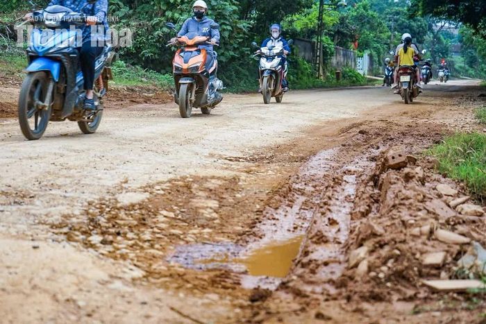 Mỗi khi có phương tiện chạy qua, bụi từ mặt đường cuốn lên mù mịt. Một số gia đình sống dọc tuyến phải dùng bạt che chắn nhà cửa để hạn chế bụi.