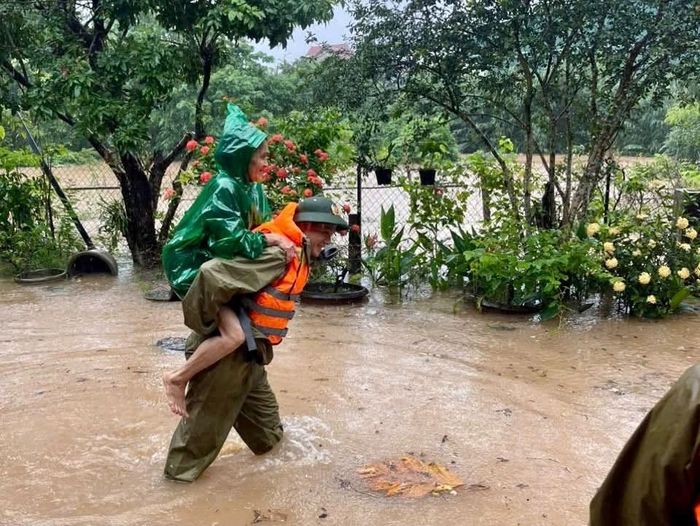 Lực lượng Công an xã Lao Bảo hỗ trợ di dời người dân ra khỏi vùng nguy hiểm. Ảnh: Công an xã Lao Bảo
