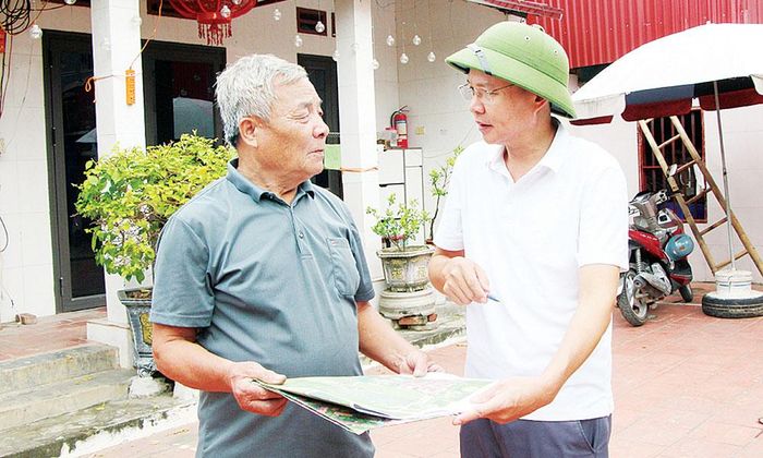 Cán bộ Trung tâm Phát triển quỹ đất tỉnh giải thích, trao đổi với người dân xã Lương Tài liên quan đến bồi thường giải phóng mặt bằng.