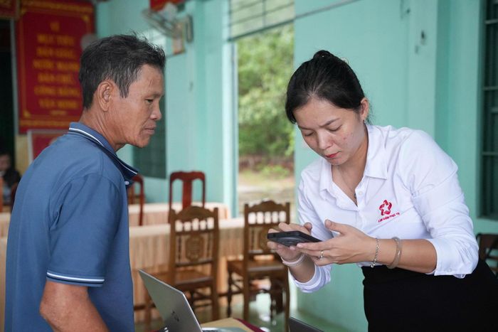 Hướng dẫn người dân cập nhật thông tin qua điện thoại. Ảnh: NGUYỄN QUỲNH