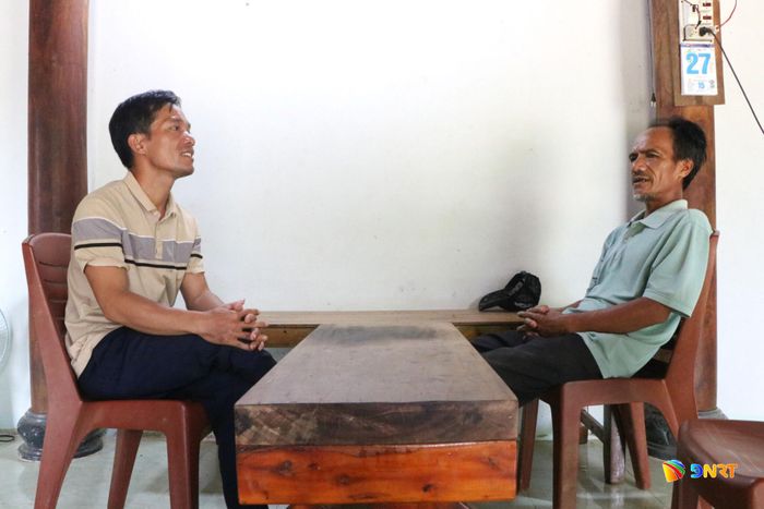 Ông Hồ Văn Siêm đến từng hộ dân thôn 2 tuyên truyền, vận động hiến đất, cây trồng để mở đường. Ảnh: THÚY HIỀN