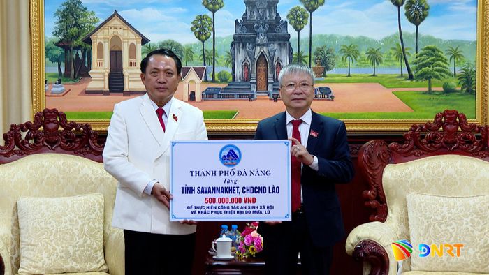 Phó Bí thư Thành ủy, Chủ tịch HĐND thành phố Nguyễn Đức Dũng trao hỗ trợ cho tỉnh Savannakhet. Ảnh: HOÀN VŨ