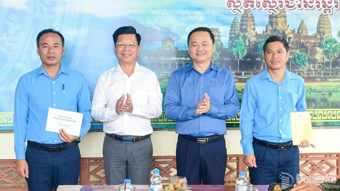 Đại tá Nguyễn Thanh Phong, Thành ủy viên, Chính ủy Bộ Chỉ huy Quân sự, Phó Trưởng ban Thường trực Ban Chỉ đạo Đồng Nai (thứ 2 trái qua) và Đại tá Bùi Đăng Ninh, Tỉnh ủy viên, Chính ủy Bộ Chỉ huy Quân sự, Phó Trưởng ban Thường trực Ban Chỉ đạo Tây Ninh (thứ 2 phải qua) tặng quà động viên Đội K72 Đồng Nai. Ảnh: ĐVCC